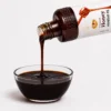 Black Seed Flower Honey bottle pouring into a glass bowl - Eco Foods