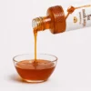 Mustard Flower Honey bottle pouring into a glass bowl - Eco Foods