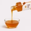 Sundarban Wild Comb Honey bottle pouring into a glass bowl - Eco Foods