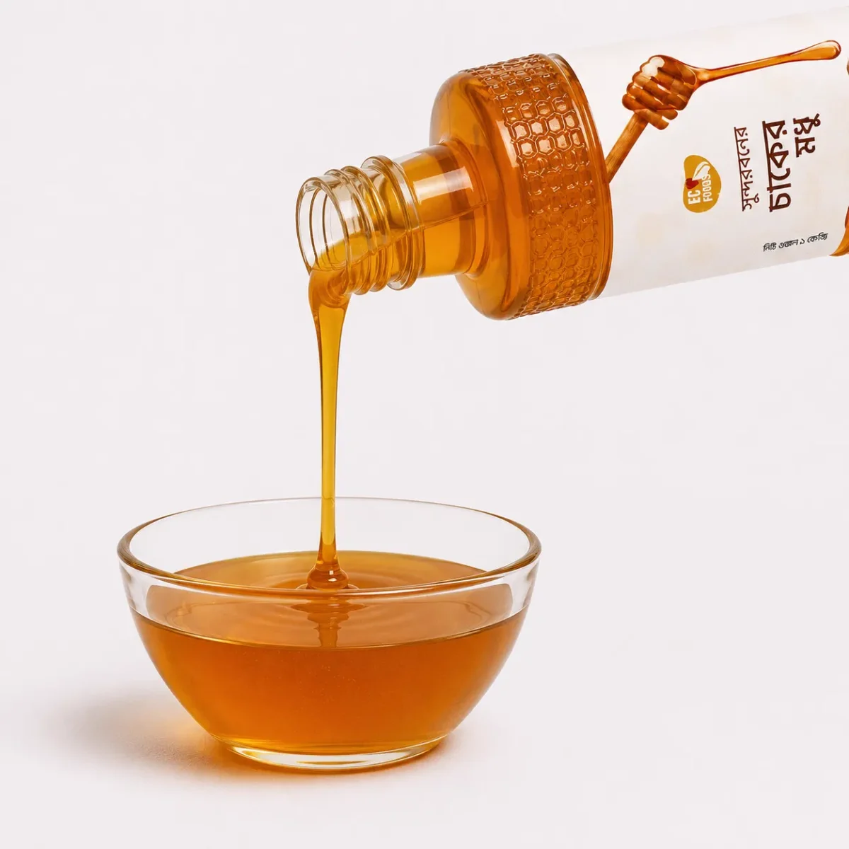 Sundarban Wild Comb Honey bottle pouring into a glass bowl - Eco Foods